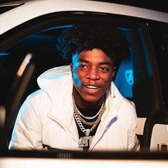 a young man sitting in the drivers seat of a car