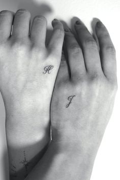 two hands holding each other with the letter f tattooed on their wrist and one hand in the air