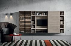 a living room with an entertainment center and bookshelves on the wall next to a chair