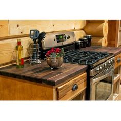 a stove top oven sitting inside of a kitchen next to a counter with cooking utensils on it