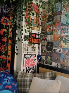 a bedroom with posters on the wall and plants growing over the headboard in the corner