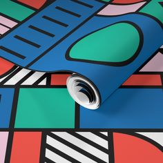 a roll of blue wrapping paper sitting on top of a colorful wallpaper design with lines and shapes