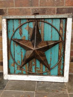 an old rusty metal star on a blue wooden background in front of a brick wall