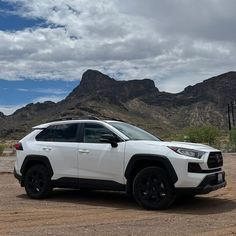 a white toyota rav parked in front of mountains