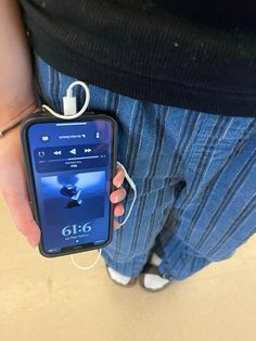 a person holding an mp3 player in their left hand and listening to music on the other