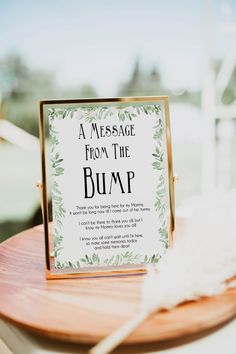 a message from the bump sign sitting on top of a wooden table next to a white feather