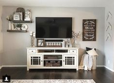 a flat screen tv sitting on top of a white entertainment center