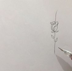 someone is drawing a flower on paper with a pen