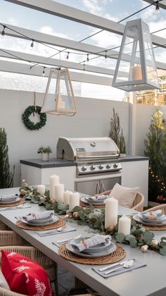 an outdoor dining area is decorated with greenery, candles and christmas wreaths on the table