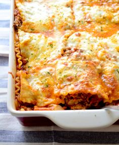 a casserole dish with meat, cheese and sauce in it on a table