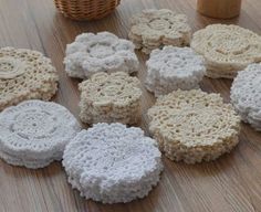 nine crocheted coasters on a wooden table next to a basket and cup