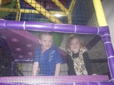 two children in a purple and yellow trampoline at the indoor play area for kids