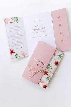 the wedding stationery is laid out on top of each other, with pink and white flowers