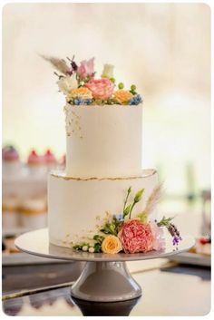 a three tiered white cake with flowers on it