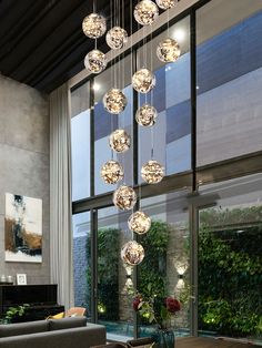 a dining room table with chairs and lights hanging from the ceiling