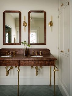 a bathroom with two sinks and mirrors on the wall