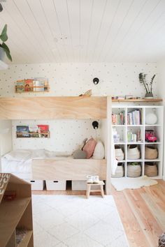 there is a bunk bed in the room with bookshelves on the wall and shelves above it