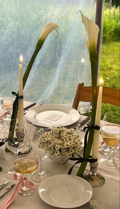 the table is set with flowers and candles