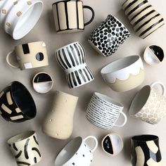 many different cups and saucers are arranged on a table top, including one that has been made to look like zebras