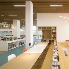 an empty library with bookshelves and tables full of books in the middle of it