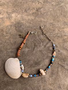 Cockle and drill shell ankle bracelet. Glass and brass beads. Bronze cross charm. 9 1/2" expandable to 11 1/2" double stranded leather ankle bracelet. Hand crafted silver plated hook and ring closure. Hand-strung Waxed Cord Bracelet Jewelry, Hand-strung Waxed Cord Bracelet, Nickel Free Bohemian Shell Jewelry, Bohemian Nickel-free Shell Jewelry, Adjustable Wire Wrapped Beaded Bracelets For Beach, Adjustable Nickel-free Shell Jewelry, Adjustable Shell-shaped Nickel-free Jewelry, Nickel-free Adjustable Shell Jewelry, Adjustable Shell Jewelry Nickel Free