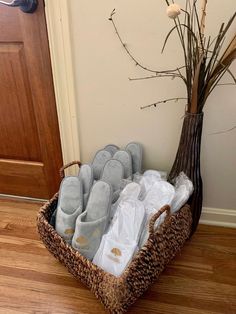 a basket filled with slippers sitting next to a tree and a door way in the background