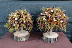 two vases filled with flowers sitting on top of a wooden table next to each other