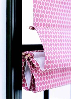 a pink and white polka dot roman blind