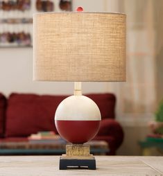 a lamp that is sitting on top of a table in front of a red couch