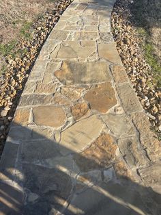 a stone path in the middle of a grassy area