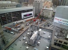 an aerial view of a city street with cars and trucks on the road in front of tall buildings