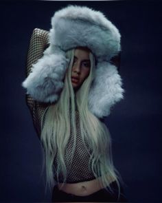 a woman with long blonde hair wearing a fur hat