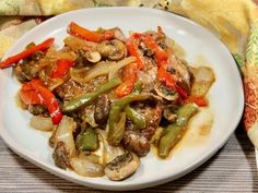 a white plate topped with mushrooms and peppers