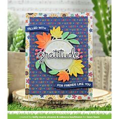 a card with the words grateful written on it and some plants in the back ground