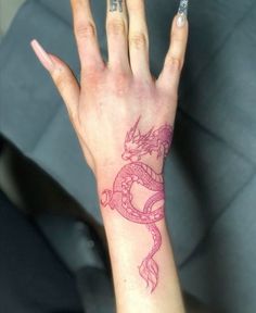 a woman's hand with a dragon tattoo on it