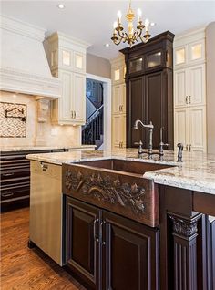 a large kitchen with an island in the middle and marble counter tops on both sides