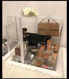 an assortment of women's personal care items in a clear box with flowers on top