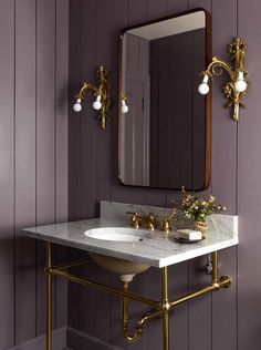 a bathroom with purple walls and gold fixtures