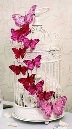 some pink butterflies in a white birdcage