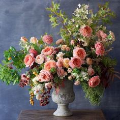 a vase filled with lots of flowers on top of a table