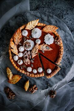 a chocolate pie with whipped cream on top and leaves around the edges, ready to be eaten