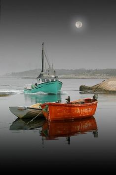 two boats are sitting in the water with one boat floating on it's side