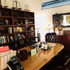 an office with many bookshelves and telephones on the desk in front of it