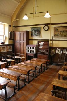 an old school room with wooden benches and desks