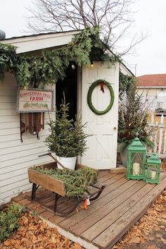 a small white shed with christmas wreaths on it