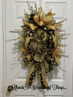 a gold and black wreath hanging on the front door