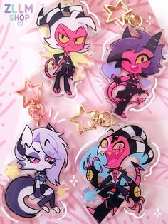 four cartoon keychais are shown on a pink and white background, with stars above them