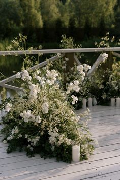 white flowers and candles on a wooden deck