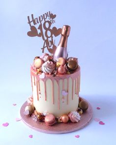 a birthday cake decorated with pink and white icing, topped with a bottle of champagne