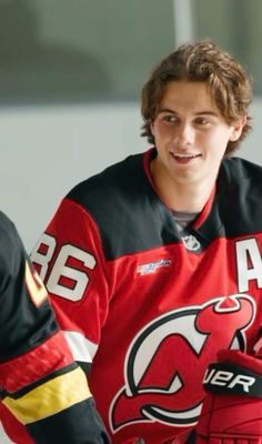 a young man wearing a red jersey and black gloves